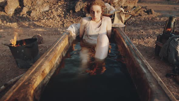 Woman Lying in Dirty Bath in Post Apocalyptic World