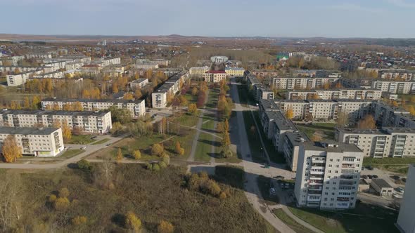 Aerial view of provincial autumn city with soviet panel houses, alley and house of culture 27