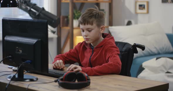 Wheelchaired Boy Using Computer