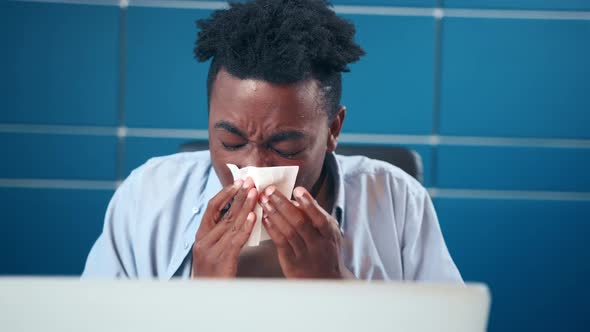 Unhappy Man in Suffering From Runny Nose Using Paper Handkerchief at Workplace