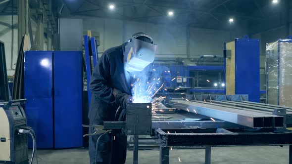 Professional Welder Working at Factory Facility. Factory Workshop with a Male Technician Welding