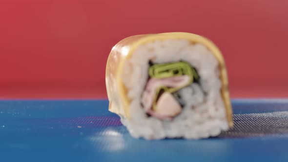 Sushi Master Cuts a Classic Roll with Chicken Cream Cheese and Lettuce