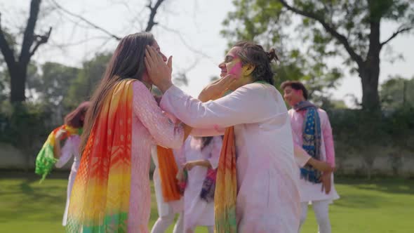 Cute Indian couple put color on each other face on Holi occasion