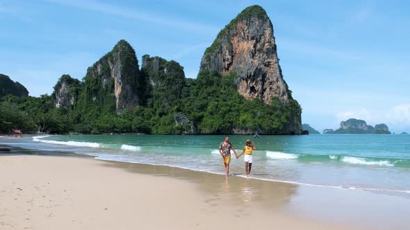 Railay Beach Krabi Thailand Couple Asian Woman and European Men Walking on the Tropical Beach of