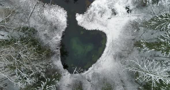 Heart Shape Sacred Spring Water Lake in Snowy Winter Forest Aerial Top View