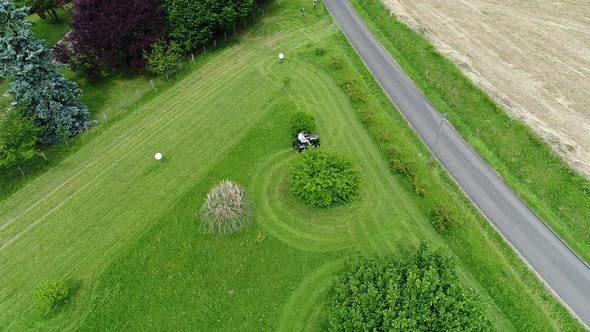 Riding lawn mower in action seen from the sky