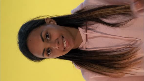 Beautiful Mixed-race Woman Making a Hush Gesture on Yellow Background.