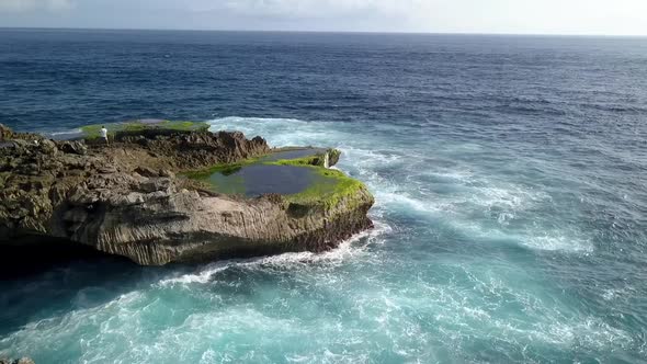 Fantastic aerial view flight slowly circle drone shotBig ocean waves crashing on the rocks of Devil