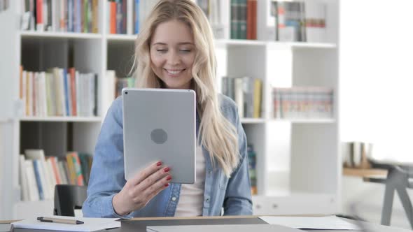 Young Woman Talking on Phone and Working on Laptop