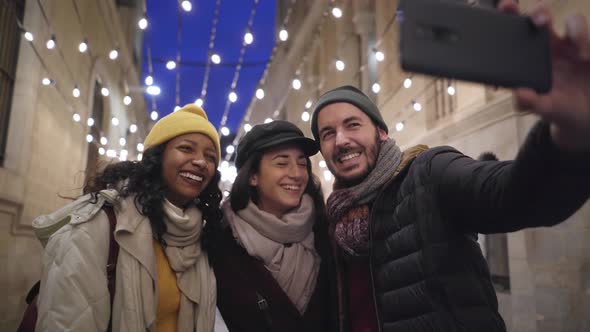 Group of Happy Friends Taking a Selfie with Smartphone in Winter Vacations in the City