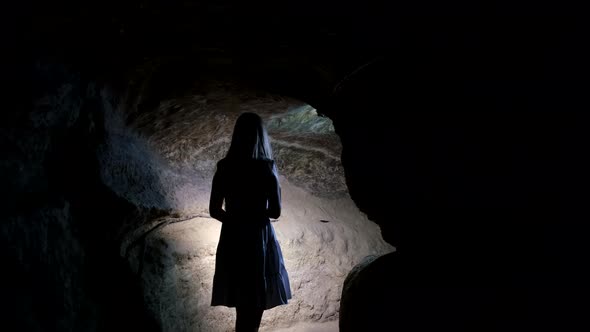 A lonely girl walks in a cave. Underground caves and tunnels