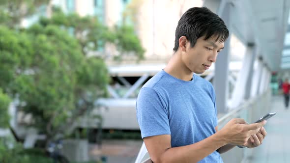 Young Man using cellphone in city 