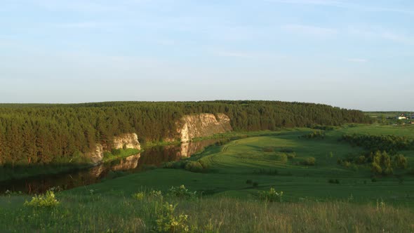 Aerial View of the River with a Rock and Forest on the Banks