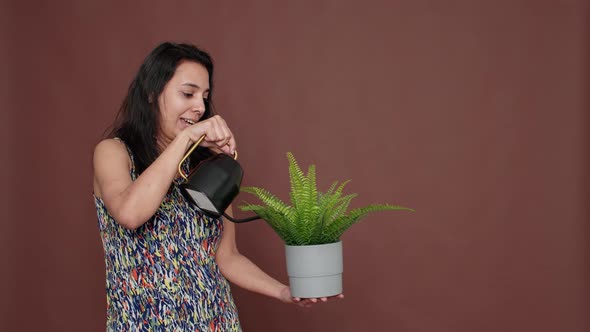 Happy Model Holding Flowerpot and Watering Green Plant