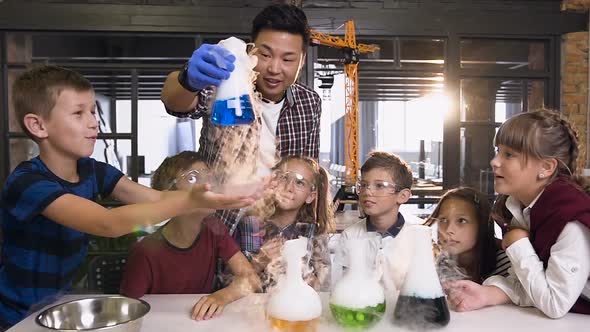 Asian Scientist Teacher Doing Experiments with Dry Ice for Children at Class