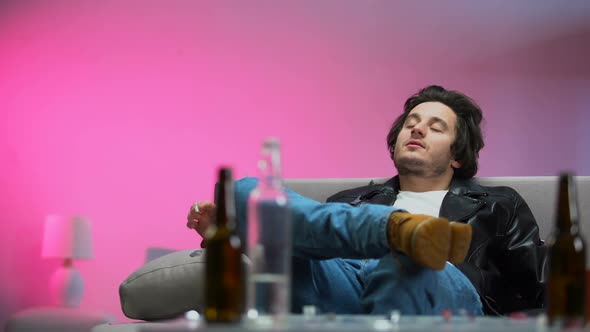 Happy Drunk Guy Chilling Out on Couch at Party, Confetti Falling Down, Relax