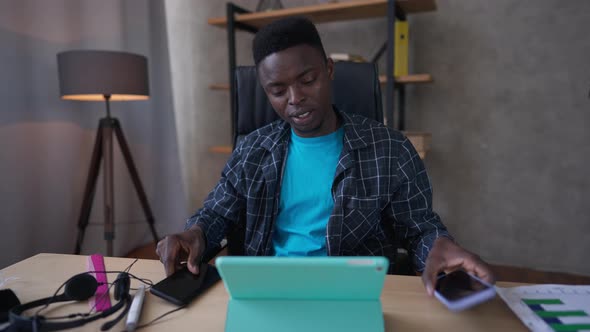 Confident Young African American Millennial Expert Talking on the Phone Hanging Up and Surfing