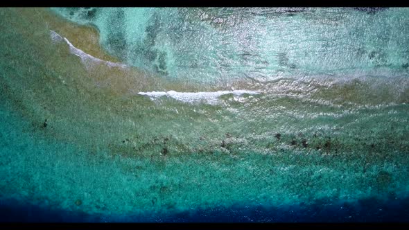 Aerial panorama of tranquil seashore beach vacation by shallow sea with white sandy background of a 