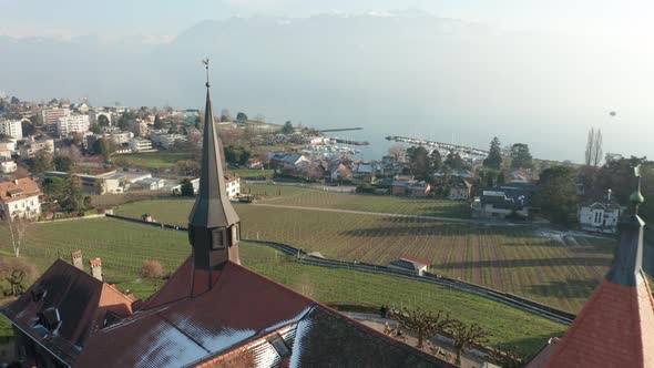 Flying past church tower overlooking green field