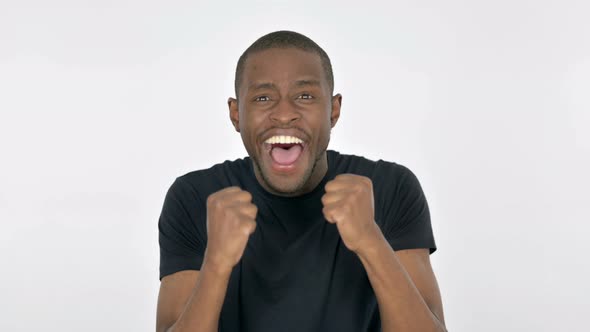 Successful Young African Man Celebrating on White Background