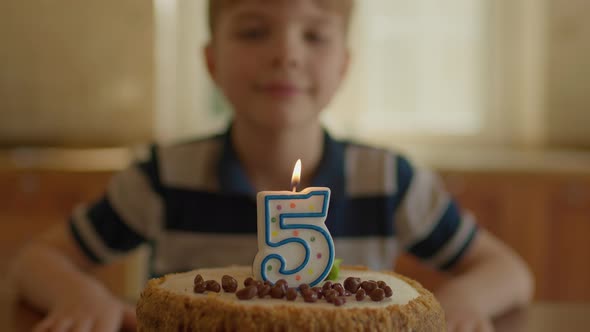 Boy Blowing Out Number 5 Candle on Birthday Cake in Slow Motion
