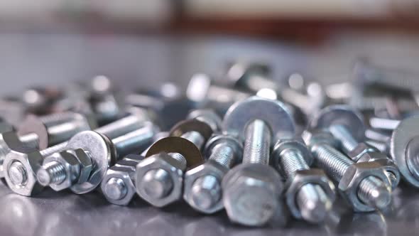 Slider Shot Video of Chrome Bolts and Nuts in a Chaotic Order Industrial Background