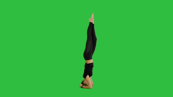 Young Woman Doing Sirsasana Yoga Pose on a Green Screen Chroma Key