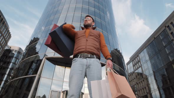 Man Holding Paper Shopping Bags Outdoors