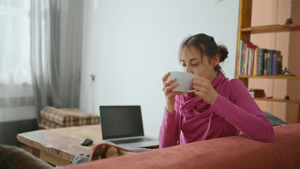 Woman Works at Her Laptop at Home Triples Her Tea Break