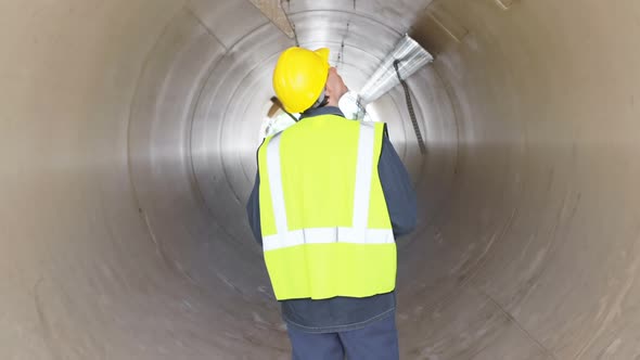 Male worker examining a concrete tunnel