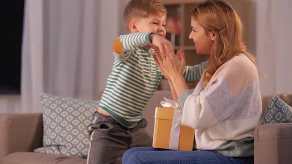 Little Son Giving Present To Mother at Home