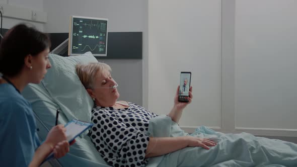 Aged Patient Holding Smartphone for Video Call with Doctor