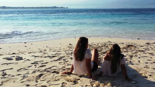 Sexy happy ladies travelling enjoying life on the beach on summer white sand and blue background 4K