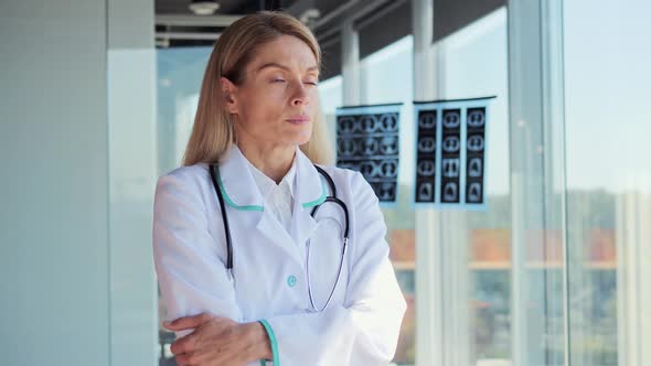 Doctor Standing Near Panoramic Window Looking Away Pensive About Problem