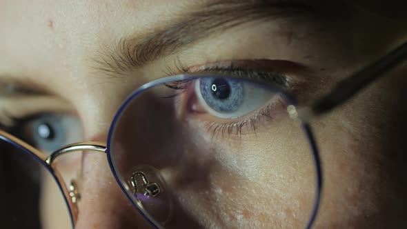 Closeup Eyes of a Teenage Girl with Glasses Looks at the Monitor Plays a Game Reads Studies