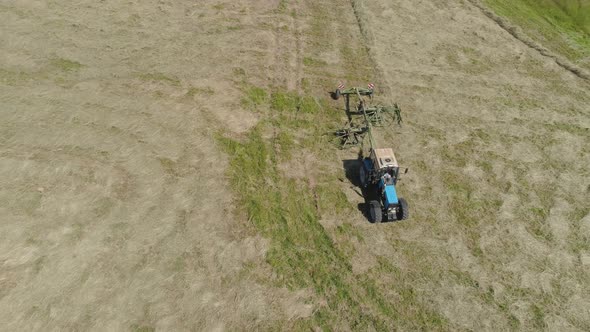 Tractor with Rake Tedders on the Farm Field