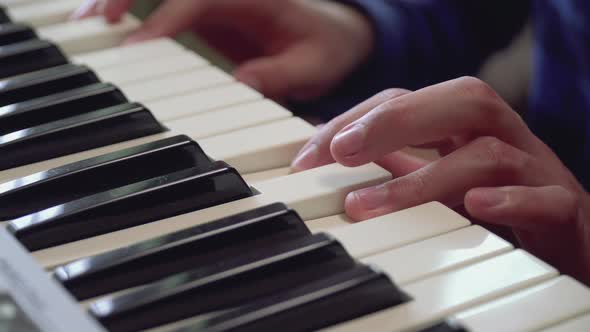 Closeup of Fingers of a Boy Learning Playing the Piano