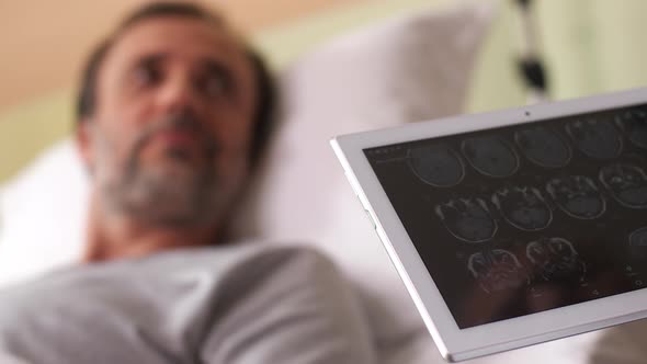 Doctor Watching Patient's Brain Scans on Tablet Pc