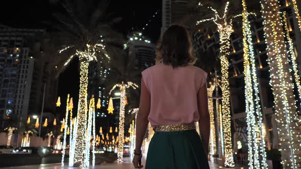 A Young Woman is Walking Along the Evening Dubai