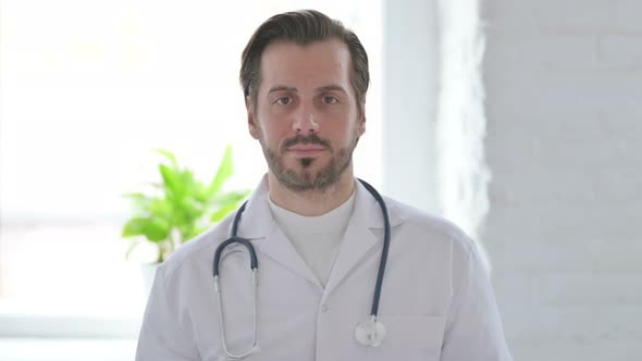 Portrait of Serious Young Doctor Looking at the Camera