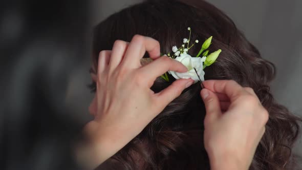 The Stylist Adorns the Girl's Hair with Delicate Flowers