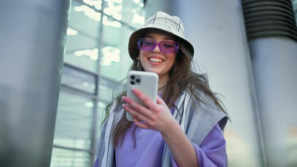 Happy Woman Walking in City Street Looking Into Mobile Phone Smartphone Screen