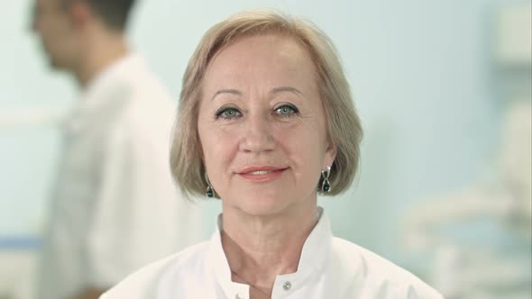 Smiling senior female doctor looking at camera