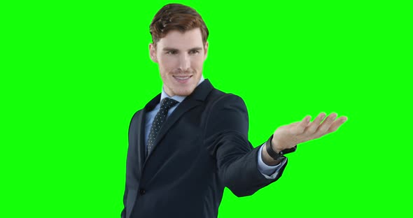 Caucasian man looking up and raising hand on green background