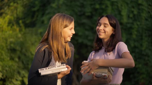 Medium Shot of Two Teenage Girls Laughing Gossiping Outdoors in Golden Sunlight