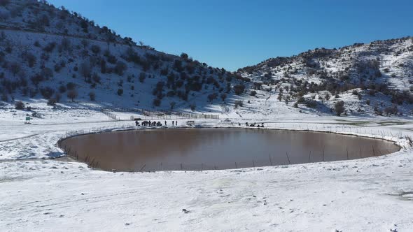 Drone orbit around a crater lake Birkat Ram on Mount Hermon in snow. Mt Hermon is the highest mounta