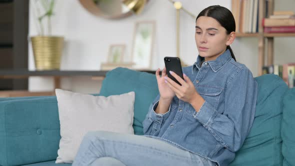 Attractive Latin Woman Using Smartphone at Work 