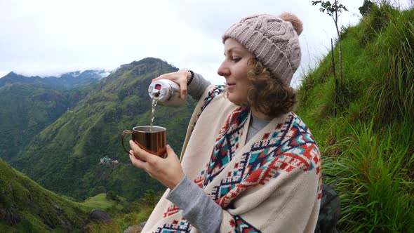 Hiker Woman Pouring Tea From Thermos In Mountains