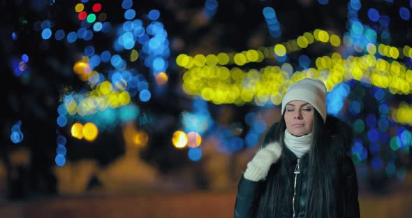 Pretty Girl Walks Along a Night Street in Winter