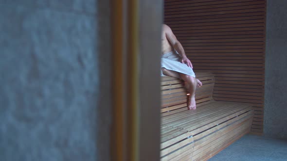 A man relaxes in a sauna at a luxury resort.